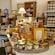 The interior of a shop displaying jars of honey and packaged goods arranged on shelves and tables